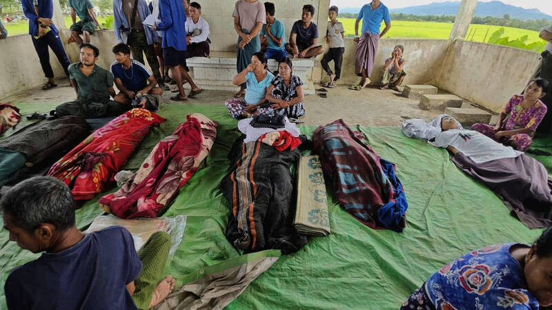 死於緬甸政府軍攻擊的罹難者遺體12日被放置在地面。（美聯社）