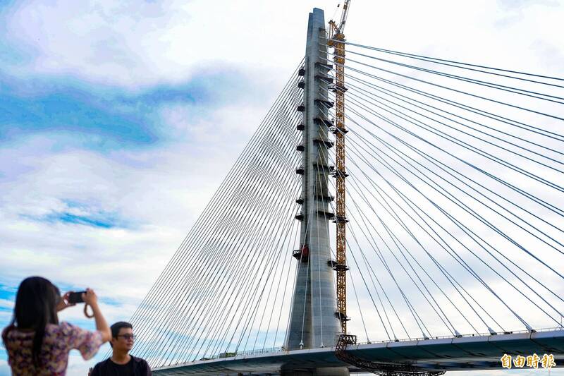 「淡江大橋」完成合龍，民眾爭相拍照打卡。（記者陳逸寬攝）