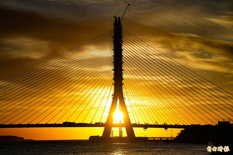 夕陽恰落「淡江大橋」主橋塔之間，勾勒出「新國門」的壯麗景觀。（記者陳逸寬攝）