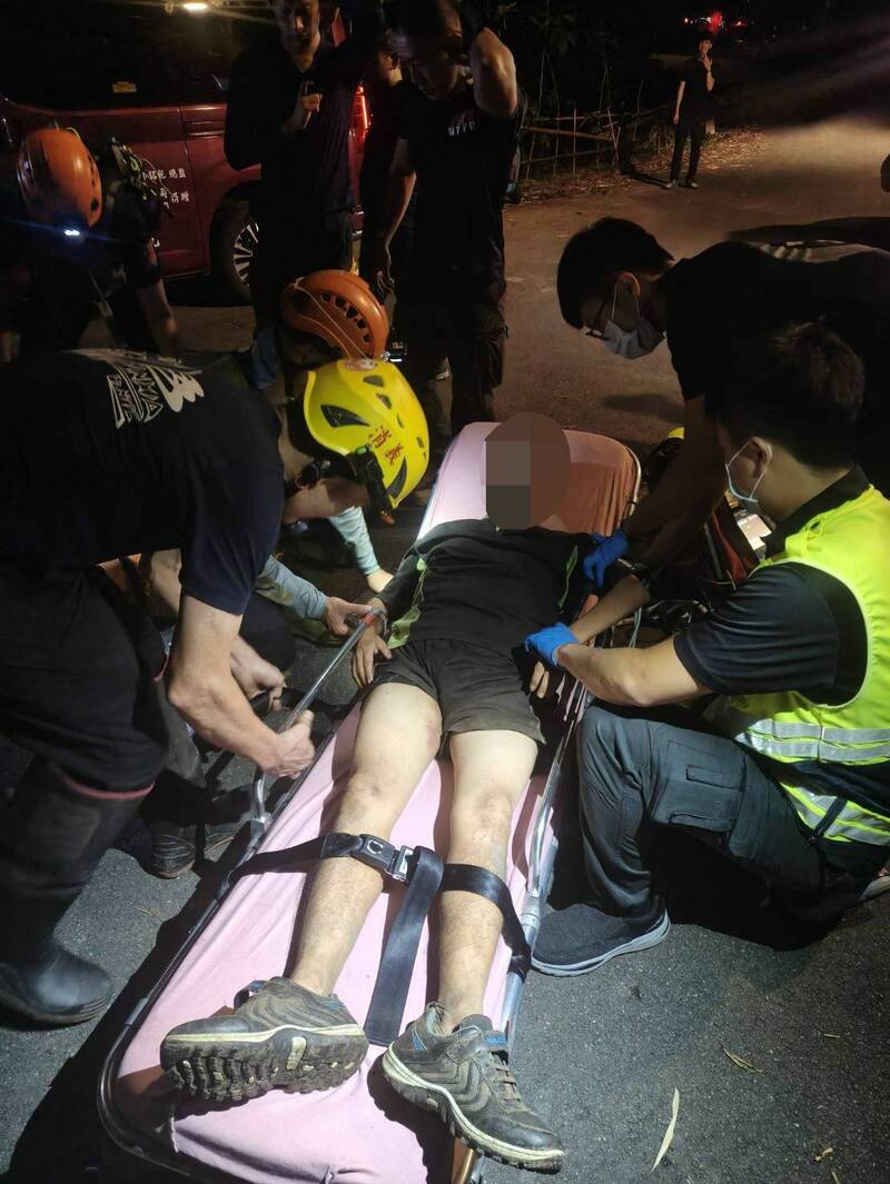 新北市三峽鳶山步道19日驚傳山難，員警騎機車先載救難人員上山，尋獲受困者及施救，隨後救難人員、員警合力抬患者下山，即時救回一命。（記者吳仁捷翻攝）