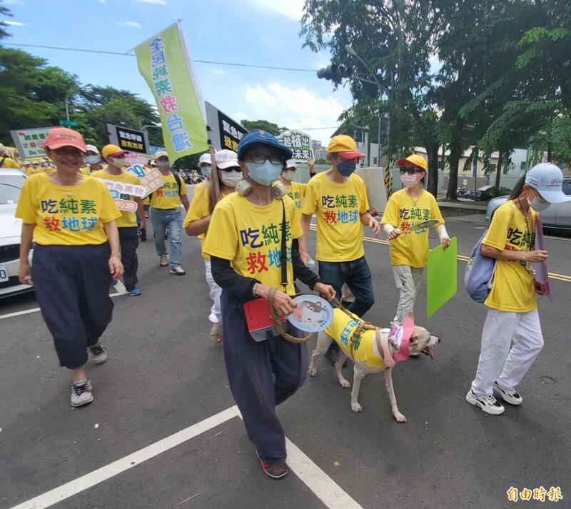 民眾帶著領養流浪犬參加，強調愛犬也吃素，強調吃素建康，更友善動物。（記者陳文嬋攝）