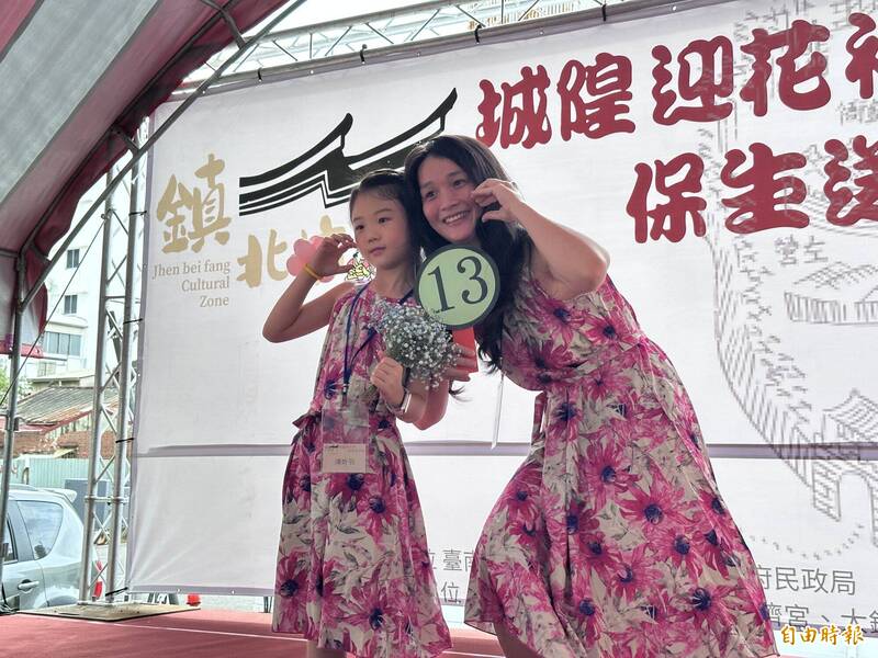 穿戴鮮花與裝飾的小花神，在全台首邑縣城隍廟埕前自信走秀。（記者王姝琇攝）