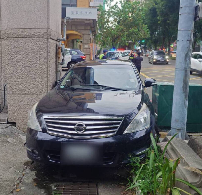 黑色自小客卡在變電箱與大樓屋角。（讀者提供）