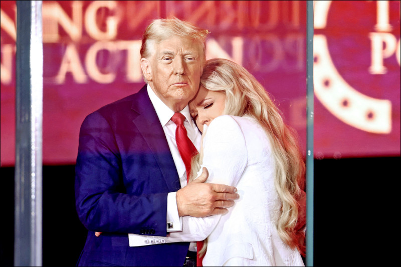 美國總統川普（左）在保守派政治網紅柯克的追悼會上，擁抱柯克遺孀艾瑞卡（右）。（法新社）