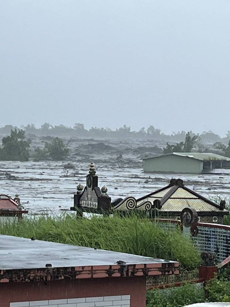 光復鄉第一公墓鄰近光復堤防，從民宅屋頂可見洪水沖入光復市區，就連公墓的祖先也泡在水裡。（民眾提供）