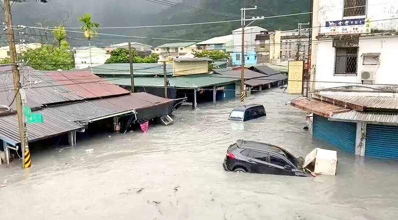 Cars are inundated by floodwaters in Hualien County’s Guangfu Township yesterday.
Photo: CNA