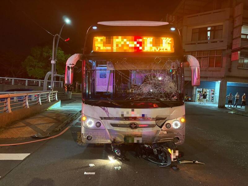 機車卡在國光客運車頭下，客運擋風玻璃也因撞擊而碎裂。（記者彭健禮翻攝）