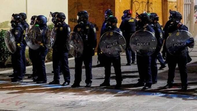 美國移民及海關執法局（ICE）探員在奧勒岡州波特蘭市的示威活動中，全副武裝成立防線（檔案照）。美國總統川普28日宣布將派遣軍隊進入該市，引發與地方政府的激烈對峙。（路透）