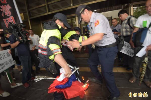 陳妙婷等人2016年6月在台北地檢署外召開「轉型正義、燒旗有理」記者會，現場也焚燒國旗抗議，員警急忙上前滅火。（資料照，記者黃耀徵攝）
