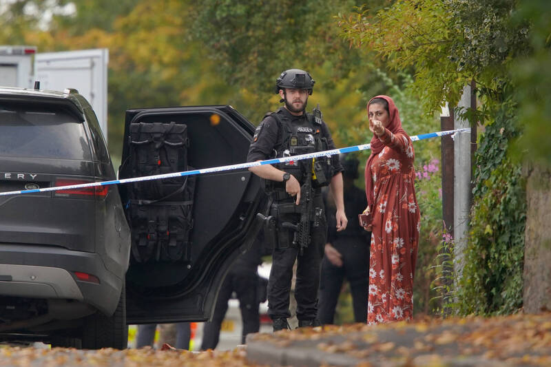 英國曼徹斯特2日發生猶太會堂攻擊案，導致3死3傷，死者中包括1名襲擊者。圖為警察在現場附近與民眾交談。（美聯社）