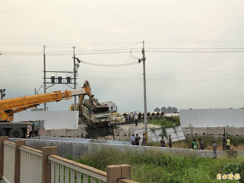 吊車將砂石車拉起。（記者王善嬿攝）
