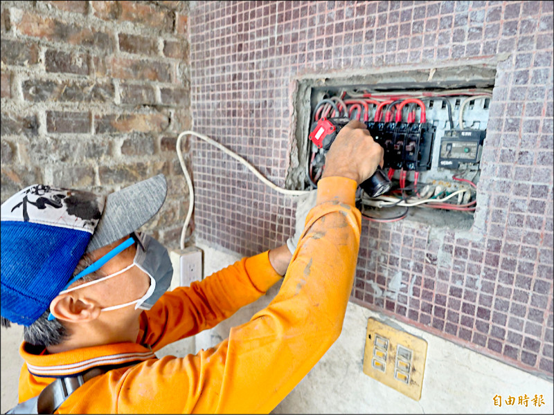 被泥水泡過的房屋，水電插座、管路也被泥巴入侵，水電超人小心清理。（記者花孟璟攝）