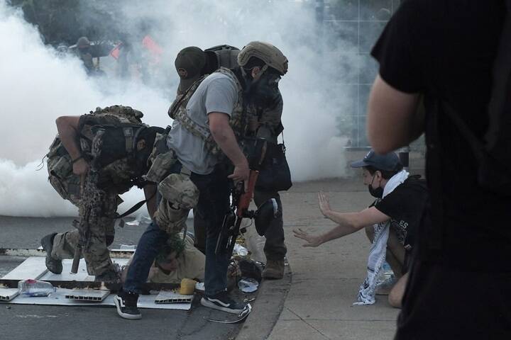 10月4日，美國聯邦移民及海關執法局（ICE）官員在芝加哥小村莊（Little Village）社區與示威者對峙，並在煙霧瀰漫中逮捕示威者。（路透）