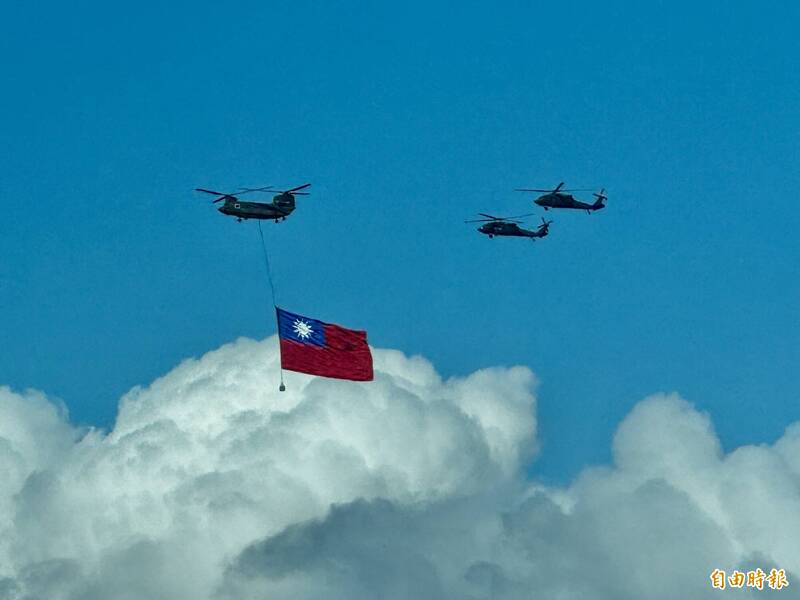 兩架CH-47「契努克」直升機吊掛巨幅國旗,並由三架UH-60M黑鷹直升機伴飛。(記者塗建榮攝) 兩架CH-47「契努克」直升機吊掛巨幅國旗,並由三架UH-60M黑鷹直升機伴飛。(記者塗建榮攝)