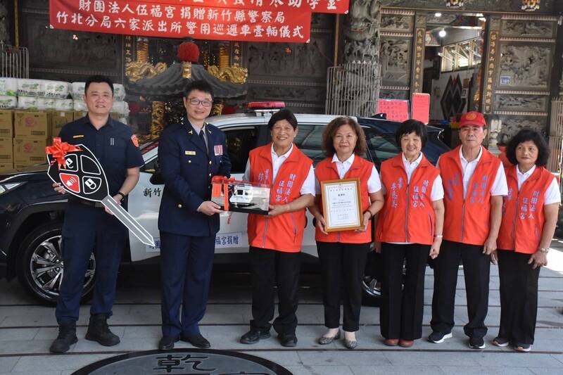 新竹縣警局長林建隆（左2）、竹北分局長吳學安（左1）代表警界，從竹北伍福宮董事長彭吉台（左3）手中接下受贈的巡邏車。（竹北警分局提供）