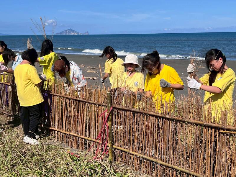 林保署宜蘭分署安排學校師生到五結鄉海邊設置「堆砂籬」，建立守護海岸的綠色防線。（圖由林保署宜蘭分署提供）