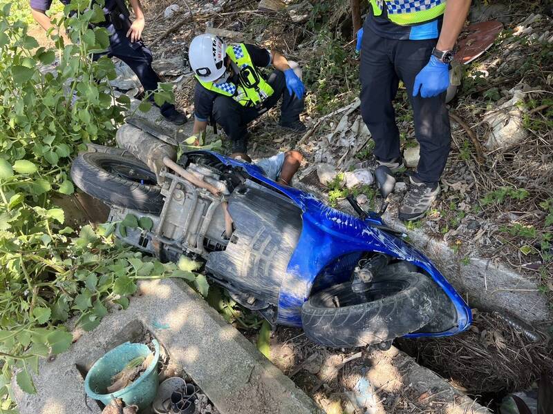 男子騎車自撞石墩，人、車卡入路旁排水溝。（民眾提供）