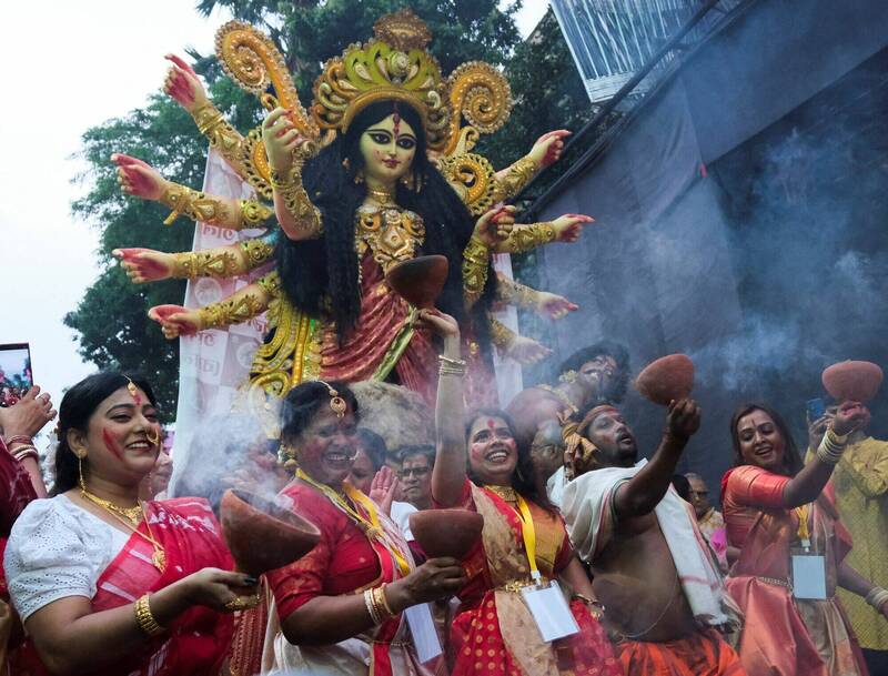 印度教信徒3日在印度加爾各答的「杜爾嘉女神節」邊護送女神神像邊手舞足蹈。（路透）