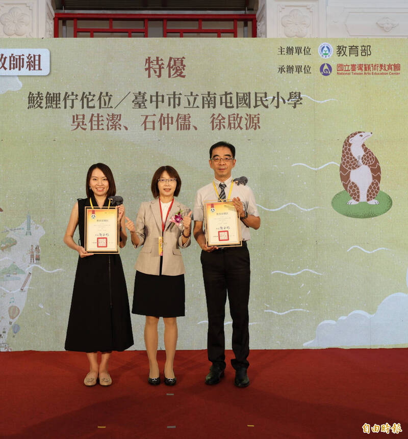 台中市南屯國小教師吳佳潔（左）、石仲儒及徐啟源（右），以台語創作的「鯪鯉佇佗位」拿下教師組特優殊榮，由教育部師藝司長武曉霞（中）頒獎。（記者林曉雲攝）