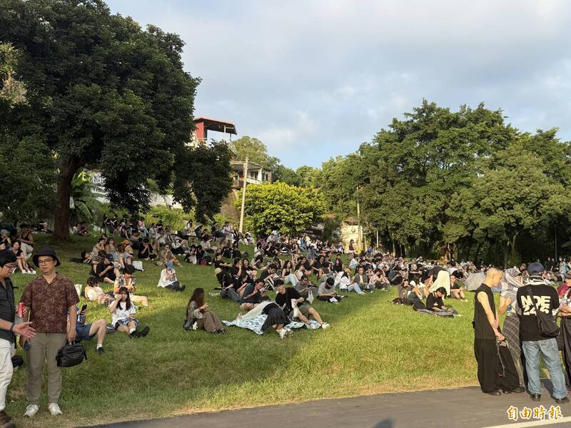 有家長帶著孩子躺在草地上沉浸旋律中，享受秋日夕陽與音樂交織的氛圍。（記者蔡愷恆攝）