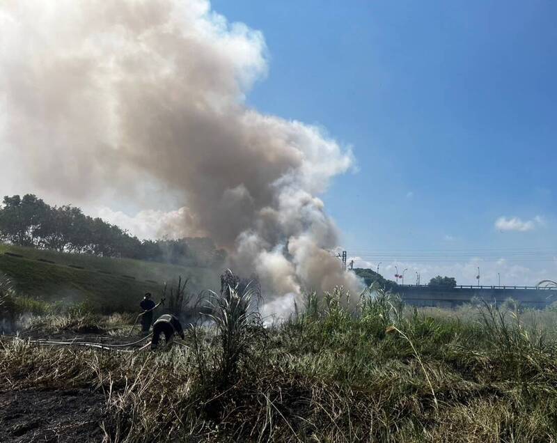 宜縣蘭陽大橋橋下雜草起火,冒出陣陣白煙。(圖由宜縣消防局提供)
