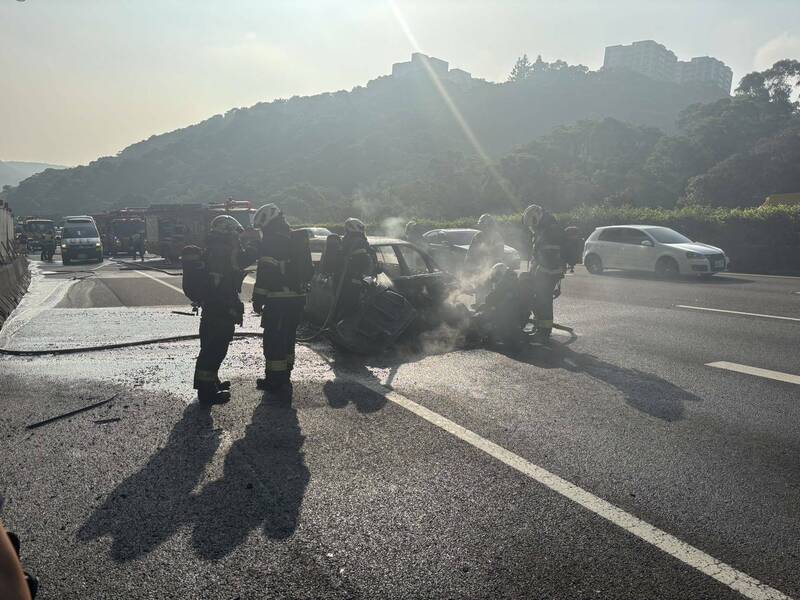 中山高南下林口今天上午七时卅分传出火烧车,驾驶与乘客两人仓皇逃生,幸无大碍,这起车祸造成中山高双向都回堵10余公里,车潮消化中;图为消防员残火处理。(记者吴仁捷翻摄) 中山高南下林口今天上午七时卅分传出火烧车,驾驶与乘客两人仓皇逃生,幸无大碍,这起车祸造成中山高双向都回堵10余公里,车潮消化中;图为消防员残火处理。(记者吴仁捷翻摄)