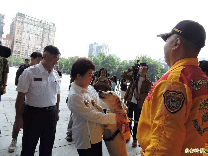 一只搜救犬扑向卢秀燕讨摸,卢秀燕一开始吓一跳,之后非常开心。(记者苏金凤摄) 一只搜救犬扑向卢秀燕讨摸,卢秀燕一开始吓一跳,之后非常开心。(记者苏金凤摄)