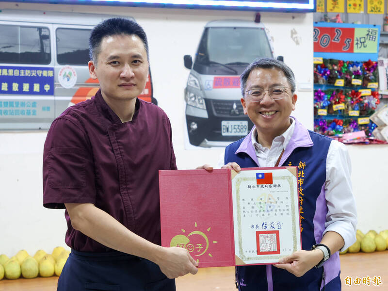 新北市社會局主秘黃逢明（右）頒感謝狀給義廚陳佳瑋（左）。（記者黃政嘉攝）