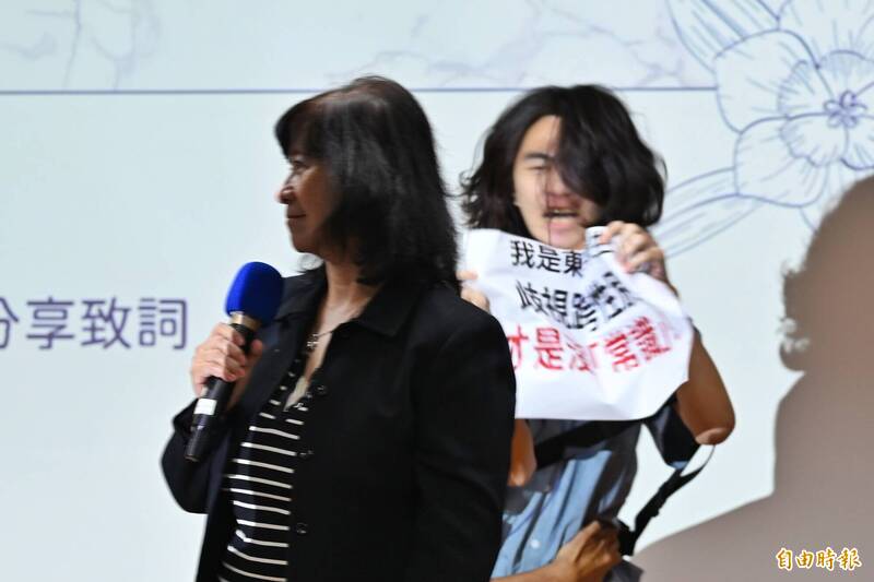 學生舉牌抗議周倪安。（記者陳逸寬攝）