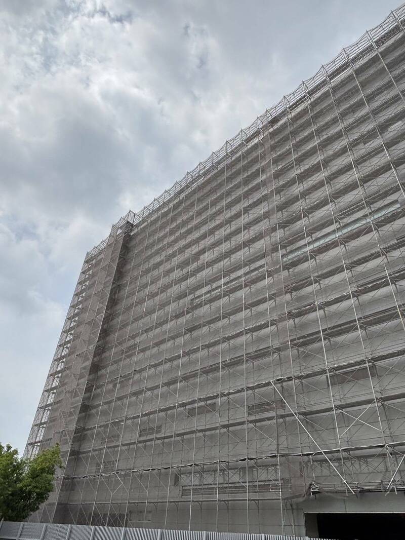 高雄市立殡仪馆附近1栋民间殡葬业者的大楼工地,遭控有工人在高空鹰架作业时未做安全带防护。(高雄市劳工局提供) 高雄市立殡仪馆附近1栋民间殡葬业者的大楼工地,遭控有工人在高空鹰架作业时未做安全带防护。(高雄市劳工局提供)
