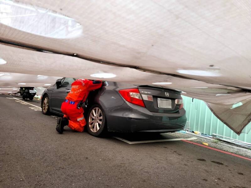 倒塌鹰架压到汽车，消防人员协助驾驶脱困。（民众提供）