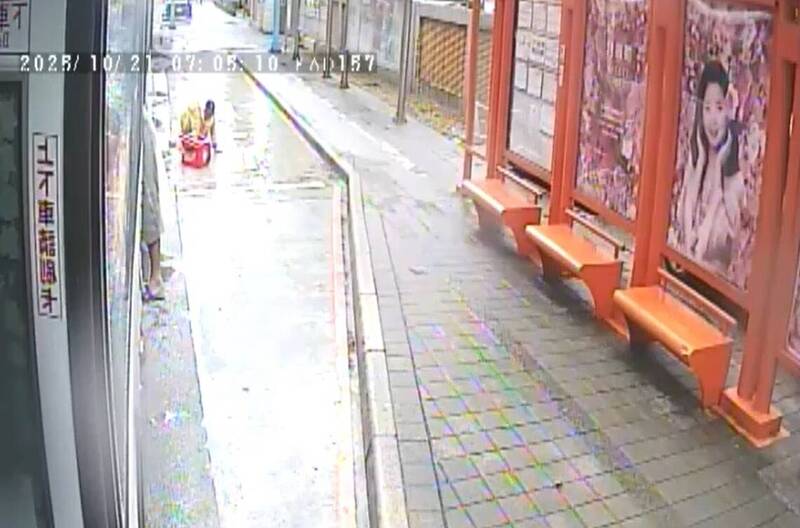 新北市1名年約60歲行動不便身障婦人雨中艱難爬行準備搭車,三重客運857路線駕駛林榮新見狀,立即下車協助,親手將她抱上車。(截取自監視器畫面) 新北市1名年約60歲行動不便身障婦人雨中艱難爬行準備搭車,三重客運857路線駕駛林榮新見狀,立即下車協助,親手將她抱上車。(截取自監視器畫面)