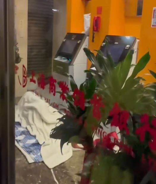 台北奇觀!霸銀行ATM反鎖玻璃門蒙頭睡 員警、路人看傻眼