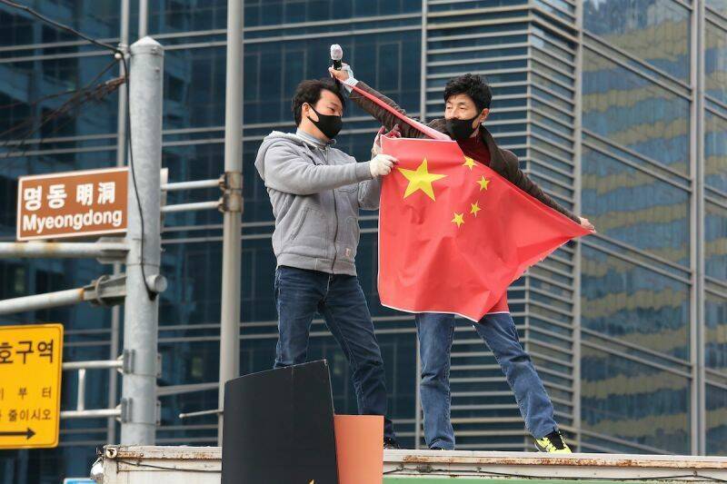 南韓保守派團體今年7月間在首爾明洞街頭舉行反中示威、撕毀中國五星旗，抗議中國干預選舉。（美聯社資料照）