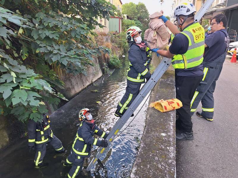消防人员处理弃婴尸体。（图由民众提供）