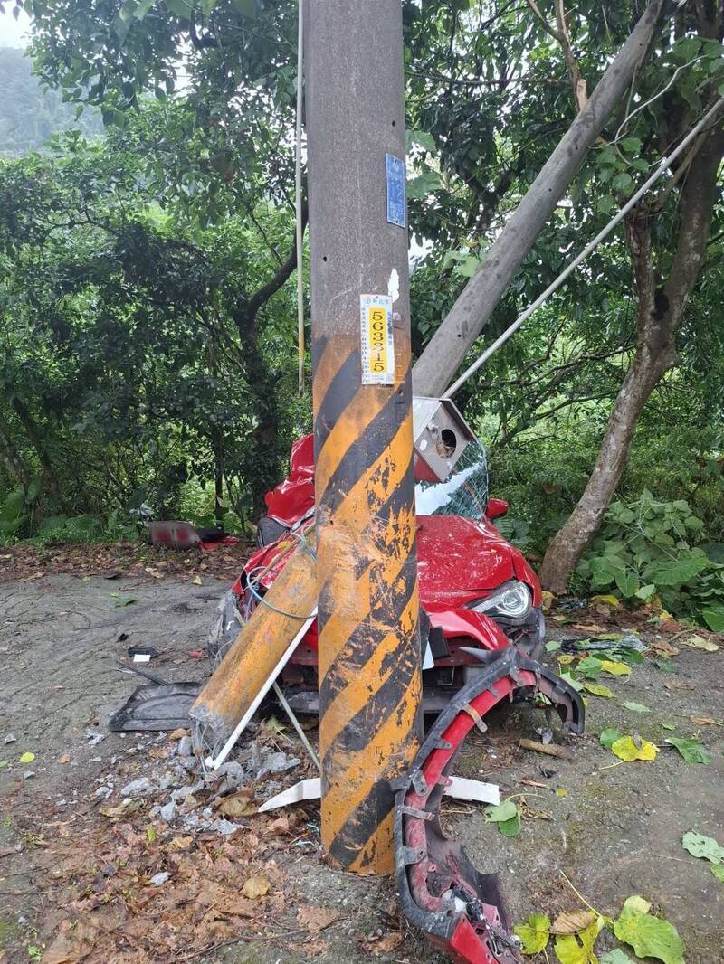 郑男驾驶跑车行经新北石碇=，疑因车速过快失控撞电线杆夹困昏迷，由消防人员破坏车体将其救出送医。（记者陆运锋翻摄）