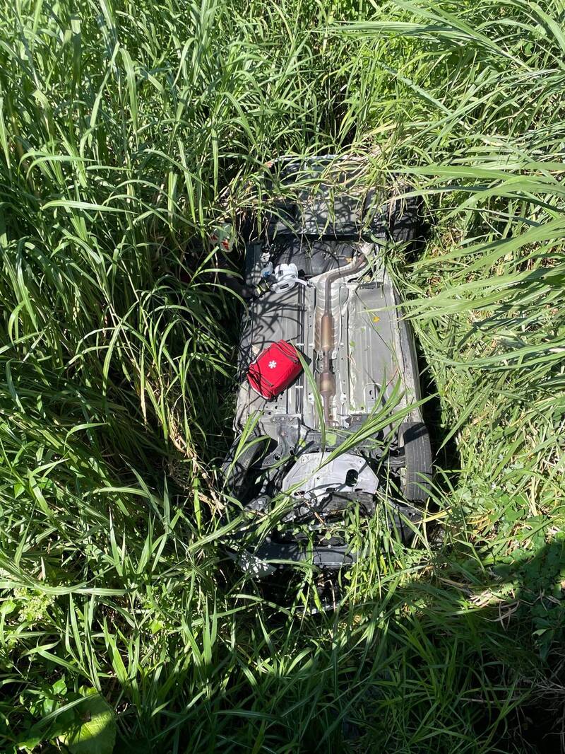 整辆自小客被长草包覆，所幸2人皆无大碍。（警消提供）