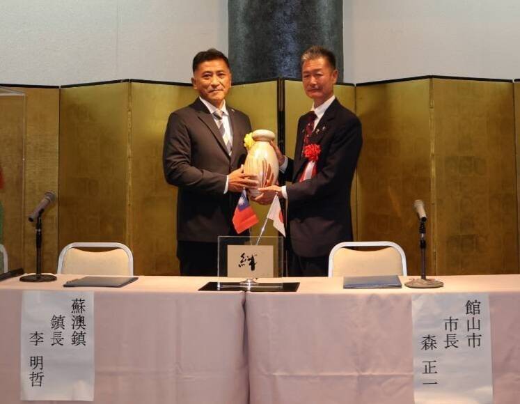 李明哲（左）致贈高溫燒製的「蘇澳冷泉燒」給館山市長森正一，象徵彼此情誼禁得起歲月焠鍊。（蘇澳鎮公所提供）