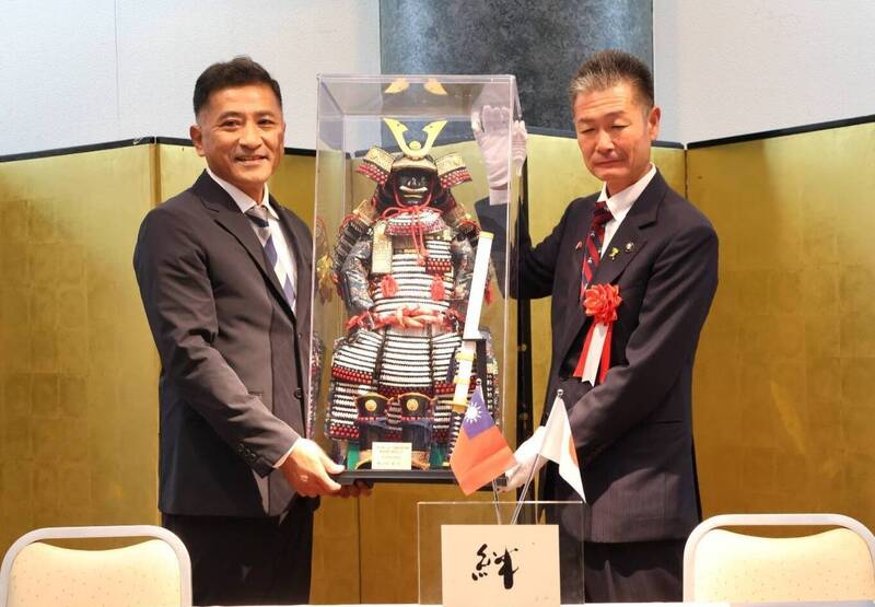 森正一（右）回贈迷你武士盔甲給李明哲，期盼彼此情誼堅定不移。（蘇澳鎮公所提供）