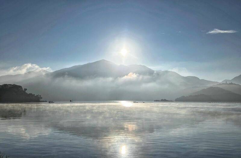日月潭受冷空氣影響，潭面飄盪薄薄晨霧，搭配山景與低雲，宛如人間仙境。（民眾提供）