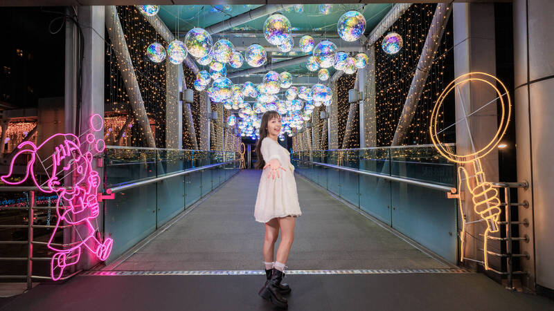 縣民大道公車站旁天橋「歡樂童心泡泡」以七彩霓虹彩球交織懸掛，營造泡泡般場景。（新北市觀旅局提供）