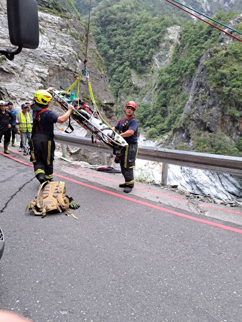 消防、搜救人员垂降到山谷后将工人吊挂上来。（民众提供）
