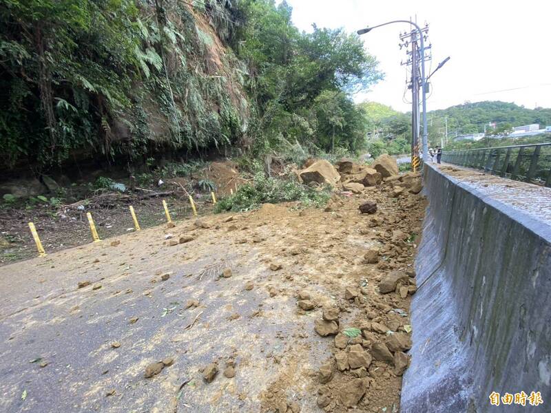 基隆市暖暖区兴隆街通往基隆金宝塔方向，今天下午约下午1点半到2点间，靠山边内侧坡地坍塌，大石头整片掉落，砸到兴隆街柏油路面上碎落一地，所幸无人伤亡。（记者俞肇福摄）