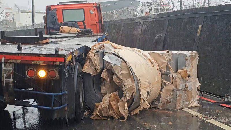 钢卷掉落路面，砸毁围墙。（记者吴升儒翻摄）