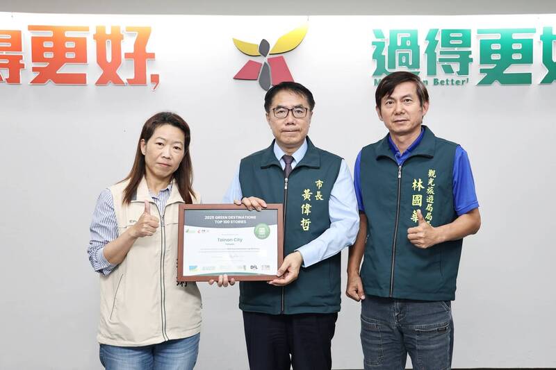 觀旅局長林國華（右1）、專委丁玲琍（左1）獻獎予黃偉哲市長。（南市觀旅局提供）