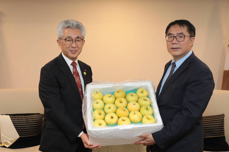 弘前市長櫻田宏（左）致贈蘋果給台南市長黃偉哲（右）。（台南市府提供）