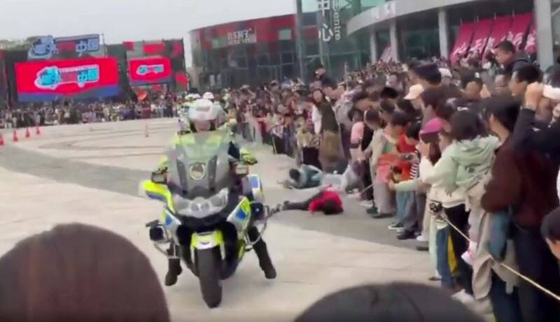 女警骑重机不慎撞翻围观民众。（取自微博）