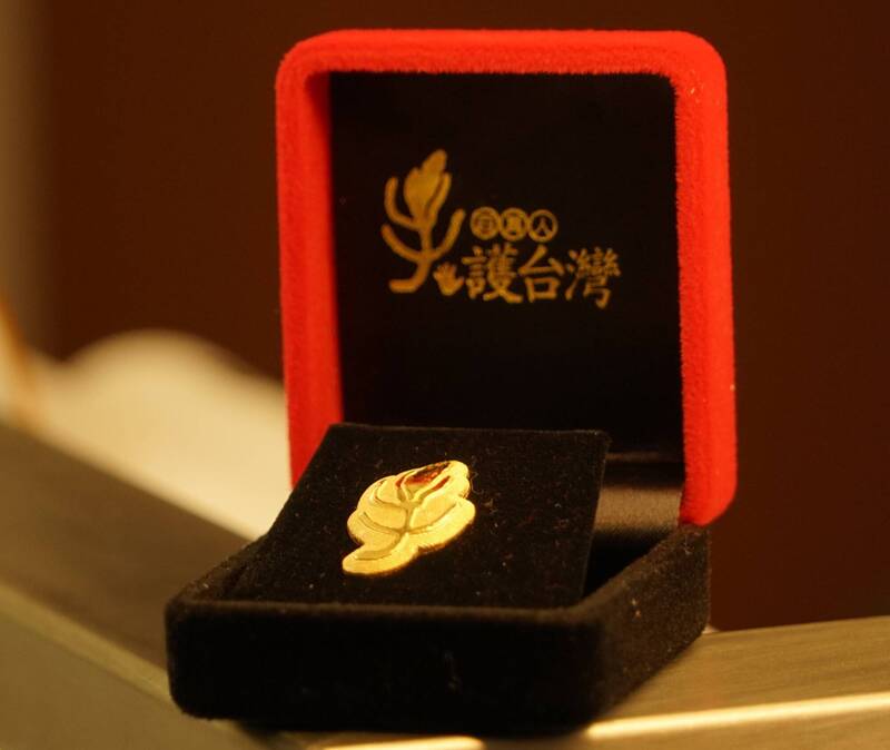 台灣國家聯盟前輩義助，捐贈2004年2月28日百萬人「牽手護台灣」運動紀念胸章，盼助台灣基進募款。（台灣基進提供）