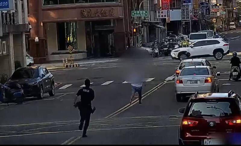 高雄李姓通缉犯拒检，警方自后追捕，他跳上友车撞警车，警对空鸣枪追捕逮人。（民众提供）
