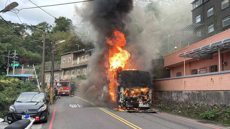 1輛停在新北市瑞芳區汽車路上的遊覽車，今天下午4時許車尾突然起火燃燒，消防隊員趕抵迅速滅火，但猛烈的火勢將遊覽車燒成廢鐵。（記者林嘉東翻攝）